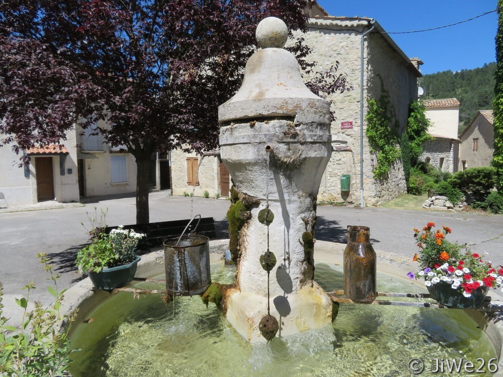 Gros plan sur la fontaine, pilier, bassin réservoir et supports en fer