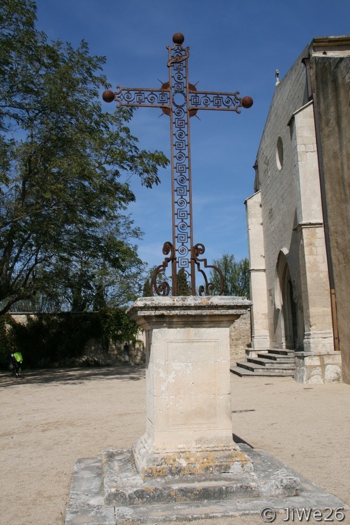 Croix en fer forgé située près de l'église Saint-Luc. Son socle carré est édifié, tout comme l'église, en pierres calcaires blanches des carrières voisines