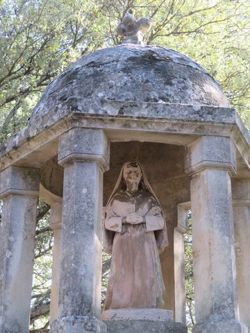 Gros plan sur la statue de Sainte-Bernadette surmontant le puits