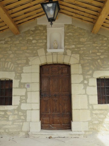 Porte encadrée de 2 fenêtres avec statue de la Vierge