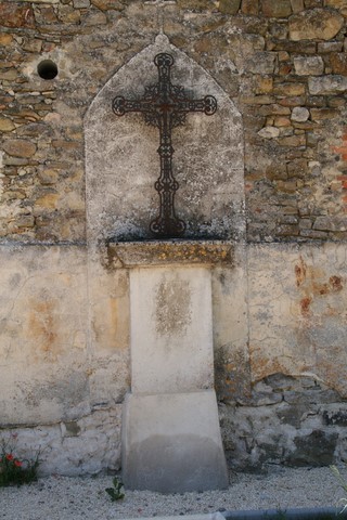 Croix adossée au mur du cimetière