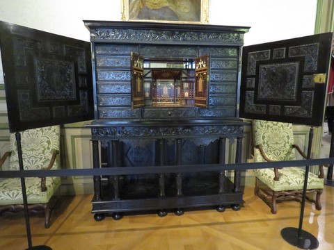 Ce cabinet, réalisé en placage d'ébène, comprend 2 portes sculptées de scènes antiques