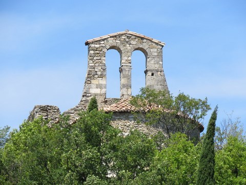 De loin, on aperçoit les vestiges du clocher de l'église Saint-Andéol ruinée