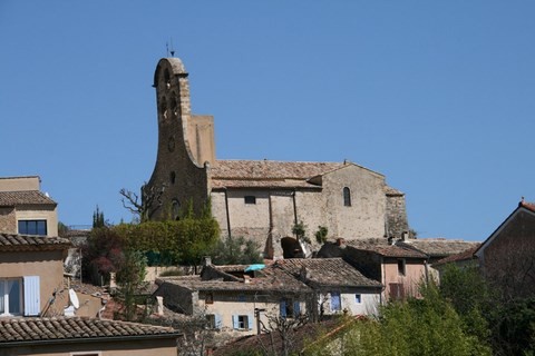 Vue du parking à l'entrée, l'église Saint-Michel et son clocher-peigne.