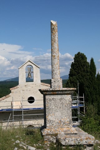 Ancienne croix de mission avec en arrière-plan la chapelle Saint-Blaise