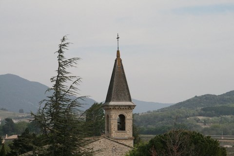 Du cimetière, on aperçoit le clocher de l'église 